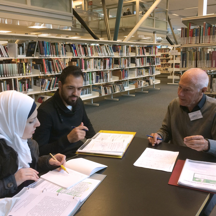 Twee cursisten krijgen Nederlandse les in de bibliotheek van Breda